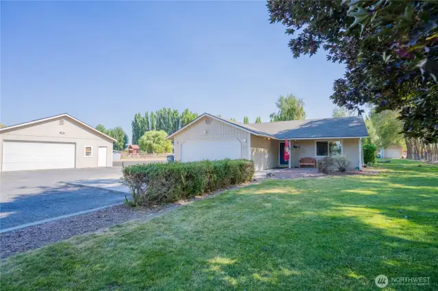 Home and shop surrounded by green grass