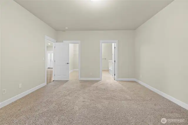 Primary bedroom looking toward 5 piece ensuite bathroom and walk in closet