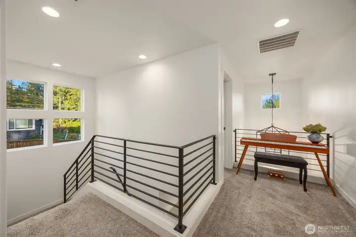 Lots of light from big windows. Lovely landing for desk or music area.