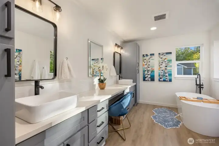Huge ensuite primary bath has dual sinks, soaking tub, and glass shower enclosure