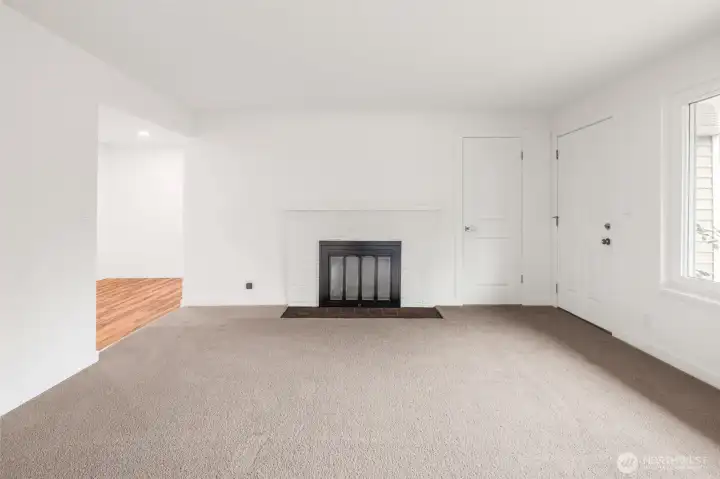 Comfortable front living space with new carpet, wood buring fireplace, and ductless mini split