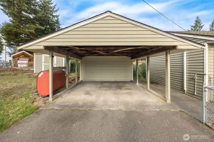 Covered Carport conveniently located near back entrace. Two storage units next to / connected to carport