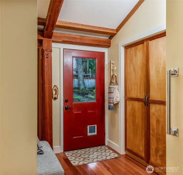 Entry way with washer and dryer tucked away and a coat closet.