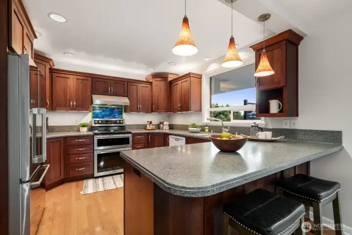 Back inside, there's a large open kitchen w/bar seating & a brand new range & fridge.