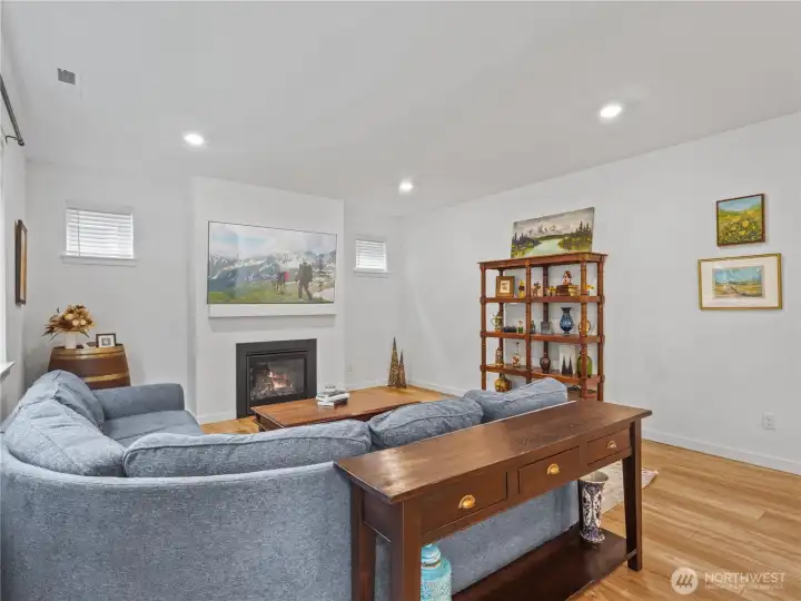 The living room opposite the kitchen has additional windows for light and a cozy fireplace for those cooler days.