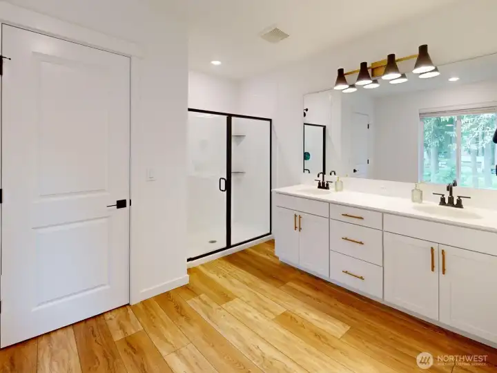 The ensuite bathroom has a double vanity, large shower, and a linen closet.
