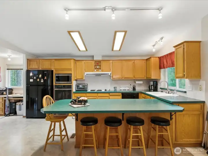 A spacious kitchen offers abundant counter space, including room for casual dining—perfect for quick meals, morning coffee, or gathering while cooking.