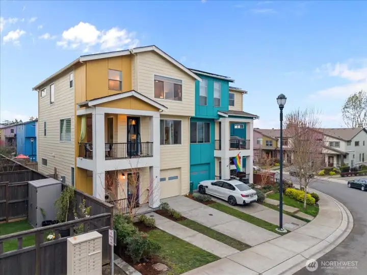 Exterior Front showcasing the home from an angled perspective, highlighting the architectural design, covered balcony, and neighborhood streetscape.