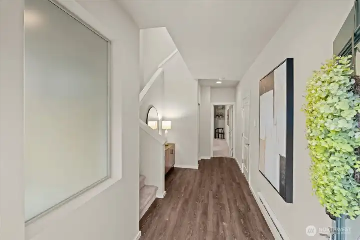Foyer featuring LVP flooring and an open hallway layout. Staircase access and recessed lighting add to the functional entry space.