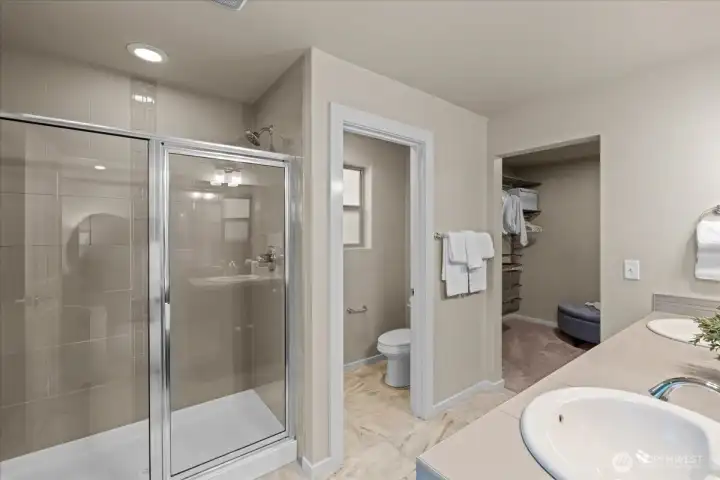 Primary Bathroom featuring a glass-enclosed shower and a dual sink vanity. Functional layout with ample counter space.