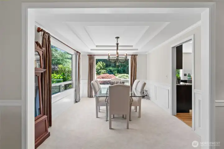 Elegant sightlines connect the living and dining rooms, where crisp millwork, generous windows, and garden views create a refined setting for everyday living and entertaining.