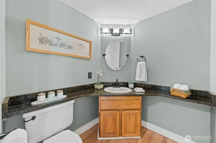 The powder room features granite countertops, an updated mirror with sleek black fixtures for a polished finish. Don't miss the corner-set design, offering convenient functionality for guests and everyday use.