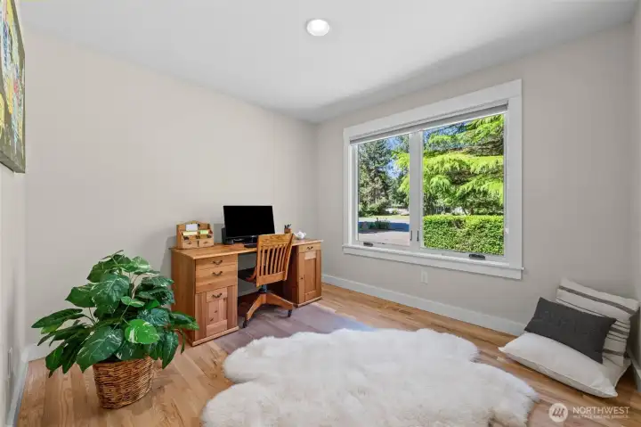 The den features hardwood floors, a large picture window framing serene greenery. There is ample space for a  desk ready for work-from-home days. Don't miss the versatile layout, perfectly suited as a home office, study, or quiet retreat.