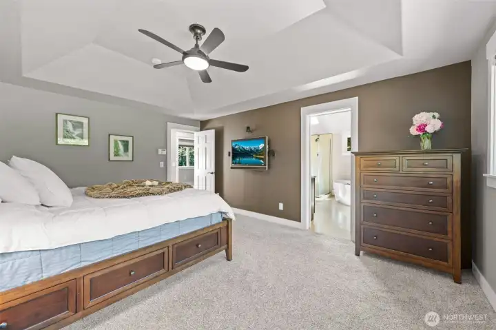 The Primary Suite offers a peaceful, generously sized retreat with vaulted ceiling, warm accent tones, and direct access to the beautifully updated ensuite bath.