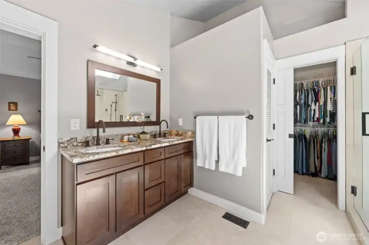 The Primary Bath features a dual-sink granite vanity with cherry cabinetry, an oil-rubbed bronze faucet set, and a generous walk-in closet just steps away. Don't miss the heated travertine floors extending throughout, adding everyday luxury to your morning routine.
