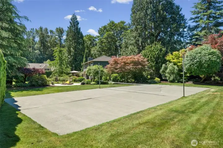 The backyard features a private sports court, surrounded by mature landscaping and towering evergreens for a true sense of seclusion. Don't miss the lush lawn framing the court, offering endless options for games, practice, or active outdoor fun. Also a great place to bring in tables and chairs for a large outdoor event!