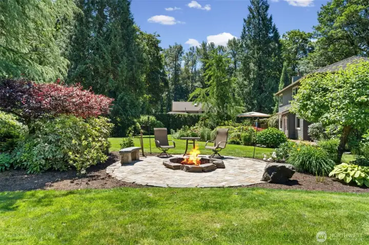 The backyard features a paver patio with a custom fire pit, tucked into a garden setting of Japanese maples and seasonal blooms. Imagine enjoying this comfortable seating area, perfect for evening gatherings or quiet conversation under the stars.