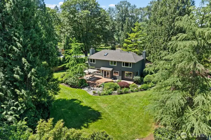 The backyard is a sprawling, park-like setting surrounded by mature evergreens, with a private well powering a 25-zone irrigation system that keeps every inch of the landscape vibrant and green. Don't miss the sheer scale of the grounds from above, offering a rare sense of privacy and space rarely found this close to everyday conveniences.