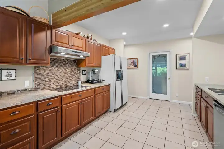 Kitchen w/Quartz Counters, Tile Backsplash and Tile Floors.
