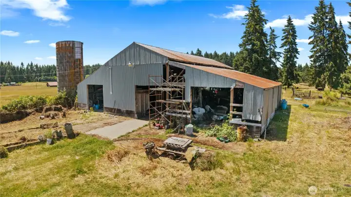 This is the 4000 sqft Barn with 2 Rooms, Hayloft and Electrical Panel. The Silo recently lost it's Roof during a wind storm but has been in use for a long time. There is a feeding trough in this area for the cows.