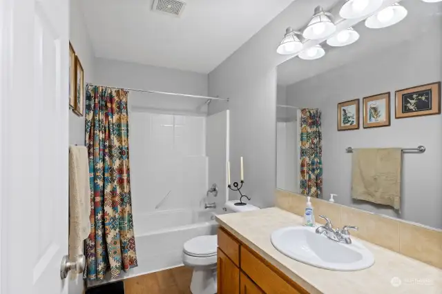 Guest bathroom, tidy and clean, with Tile counters and well lit!