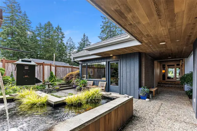 Garden patio greets you as you enter this custom home with timeless design! This gorgeous koi pond could become a water feature or a plunge pool for hot days. It's 4 feet deep!