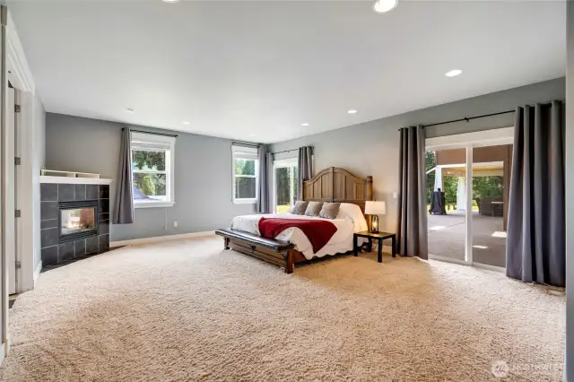 Cozy fireplace in the Primary bedroom with sliders out to the patio