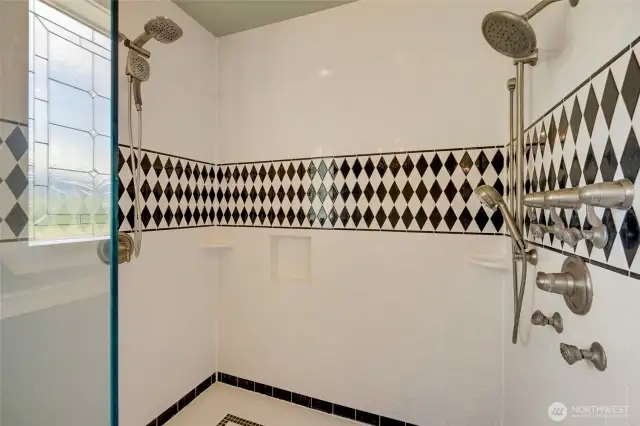 Huge walk-in shower with dual shower heads.