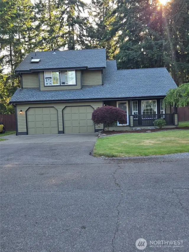 Welcome home to 25608 68th Ave E—this striking front exterior shot showcases the home’s curb appeal with a lush green lawn, long driveway, and charming covered porch. Surrounded by serene trees and natural privacy, this property blends country comfort with Northwest style. Ideal for buyers seeking peace, space, and practicality.