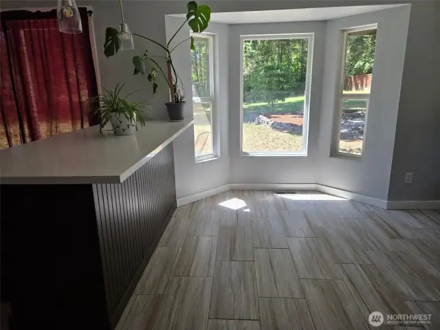 Bay windows create a bright and inviting breakfast nook, perfect for soaking in the morning light or watching the wildlife in your private yard.