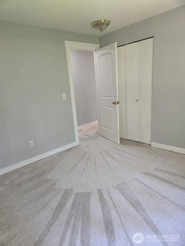 Fresh, neutral tones and plush carpet make this upstairs bedroom move-in ready. The room includes a standard closet and clean white trim, perfect for guests, a nursery, or a home office.
