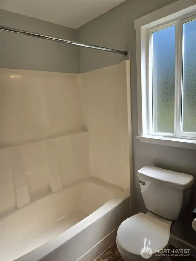 This modern guest bathroom features a sleek countertop, classic vanity, and full wall mirror.