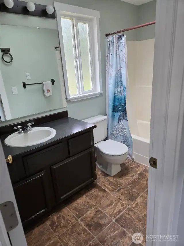 The main upstairs bathroom offers everything you need, with durable flooring, a single vanity, full tub/shower combo, and a bright frosted window for natural light with privacy.
