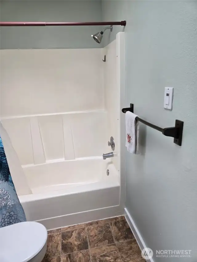 This modern guest bathroom features a sleek countertop, classic vanity, and full wall mirror.