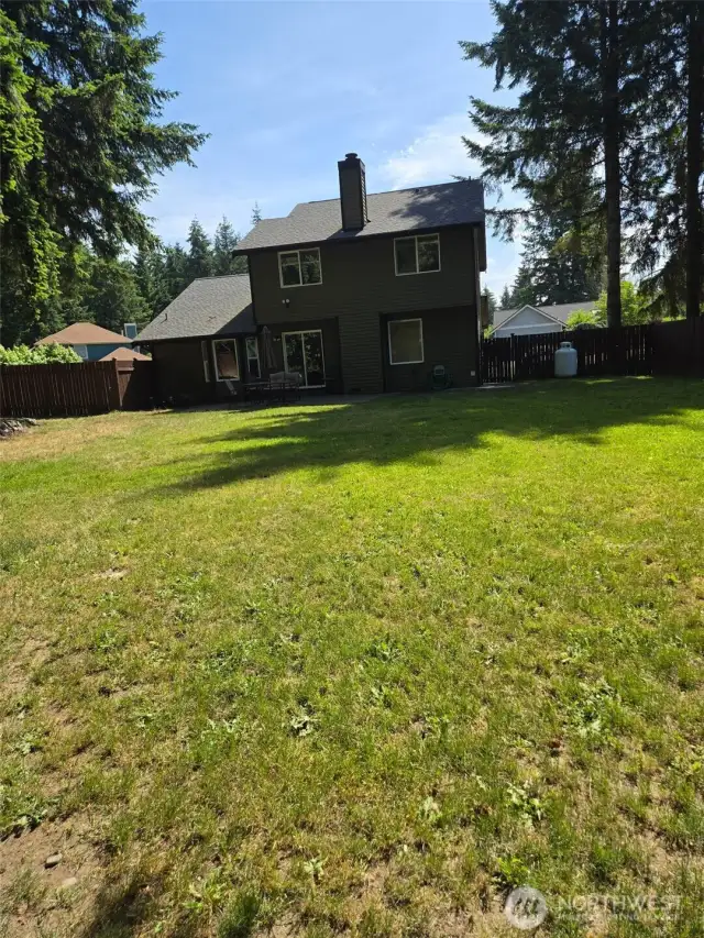 A look at the expansive backyard from the far fence line, showcasing the home’s generous lot size and peaceful setting. A rare find in Graham with this much usable yard space.