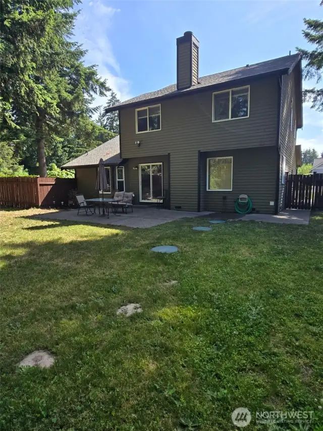 A close-up look at the backyard's lush lawn and private setting. The clean lines of the patio blend into a natural oasis that’s perfect for play or peaceful reflection.