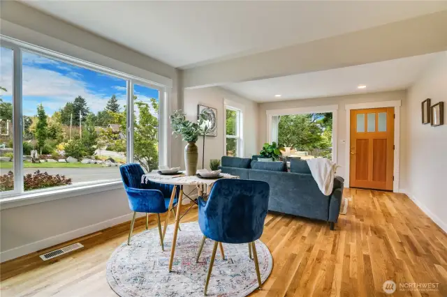 Bathed in natural light and designed for effortless flow, the dining and living room blend together with gleaming hardwood floors, and expansive windows that frame the outdoors like art.