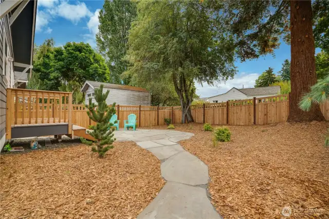 The expansive, fully-fenced backyard offers both privacy and peace of mind—ideal for entertaining, unwinding under the stars, or letting Fido roam free—while mature, diverse trees provide natural shade and beauty.