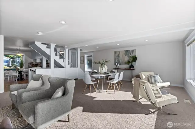 An open and airy main floor complete with powder bath, laundry, kitchen with dining space, and living room.
