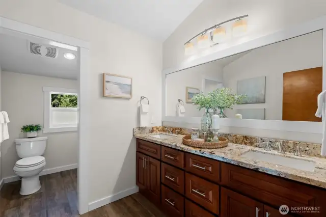 The primary bathroom is spacious and luxurious, featuring quartz countertops and tile floors.