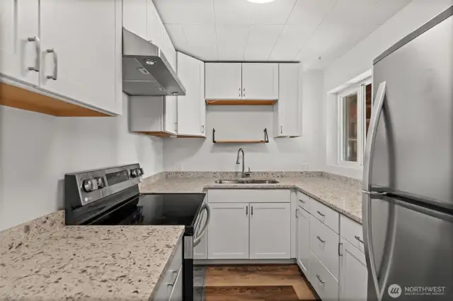 Updated kitchen with sleek hard surfaces and stainless steel appliances.
