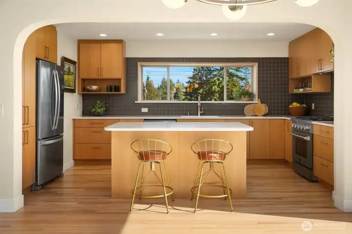 Designer kitchen with custom cabinetry, new appliances, island seating & mountain views.
