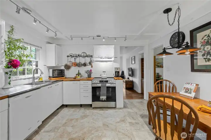 Warm and inviting kitchen featuring new stove, flooring and a very functional layout.