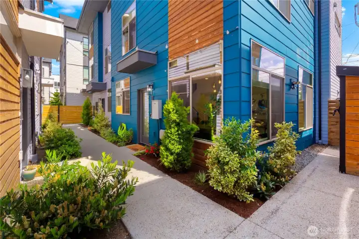 Nice and private tucked back off of the street. On the far right of this photo is convenient bike storage. Behind you, and to the left is the path to/from your dedicated parking spot, with EV charger.