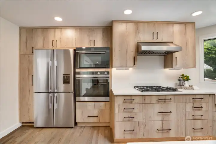 Sleek stainless appliances complement the kitchen's contemporary design. The Fisher & Paykel microwave also functions as a speed oven, offering quick and efficient cooking. Updated lighting fixtures brighten this space and continue throughout the home. Sleek stainless appliances complement the kitchen's contemporary design. The Fisher & Paykel microwave also functions as a speed oven, offering quick and efficient cooking. Updated lighting fixtures brighten this space and continue throughout the home.