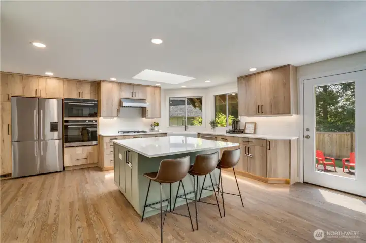 The oversized island offers additional seating, workspace, and storage, making it a natural gathering spot. Continue out the back door to see how beautifully the home connects to the back deck and fully fenced yard. The oversized island offers additional seating, workspace, and storage, making it a natural gathering spot. Continue out the back door to see how beautifully the home connects to the back deck and fully fenced yard.