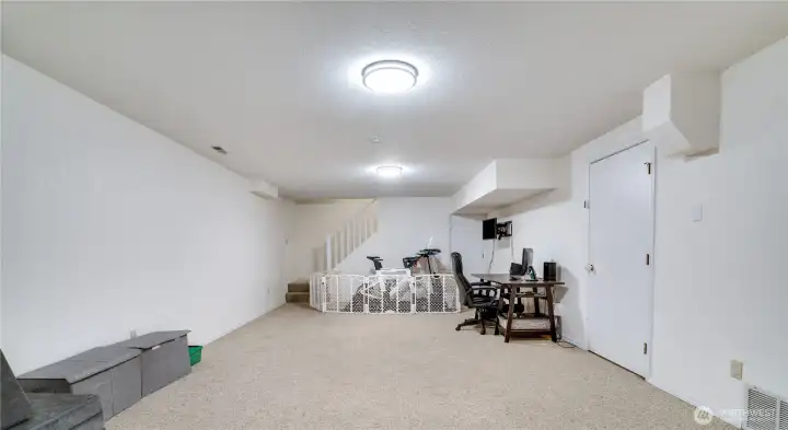The door to the right leads to the unfinished 408-square-foot area, which includes built-in shelving, extensive storage, and workspace for projects and hobbies. The door to the right leads to the unfinished 408-square-foot area, which includes built-in shelving, extensive storage, and workspace for projects and hobbies.