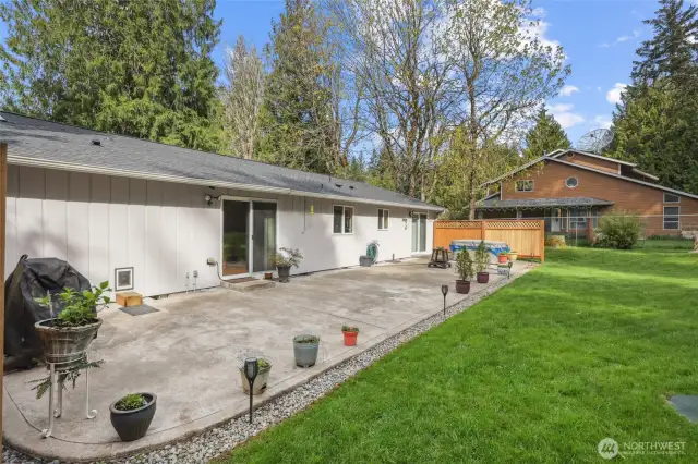 Back patio w/ privacy fence behind hot tub off primary suite