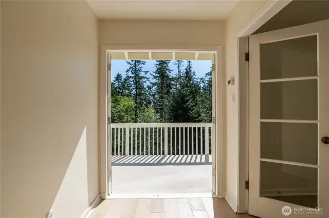 Upper hallway, looking out onto upper deck; door to primary suite to the right