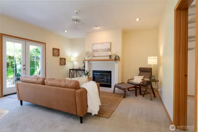 The adjacent family room features a cozy gas fireplace, creating the perfect spot for relaxing evenings or casual gatherings. French doors open to the backyard and patio, seamlessly blending indoor and outdoor living.